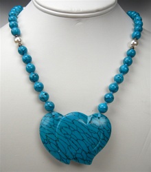 Beautiful Synthetic Turquoise Necklace. 8mm turquoise beads and off-white imitation pearls, hand knotted. Large 57x40mm double-heart ornament. Necklace is 32 inches long.